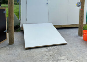A grey accessibility FRP Anti-Slip Flat Sheet ramp leading to the entrance of a white building.