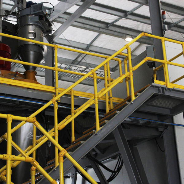 Modular FRP handrail stairway inside industrial factory.
