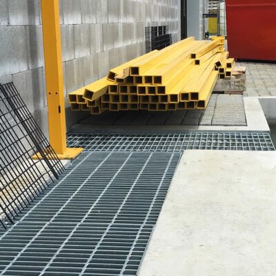 Steel mesh grating drain in industrial setting.