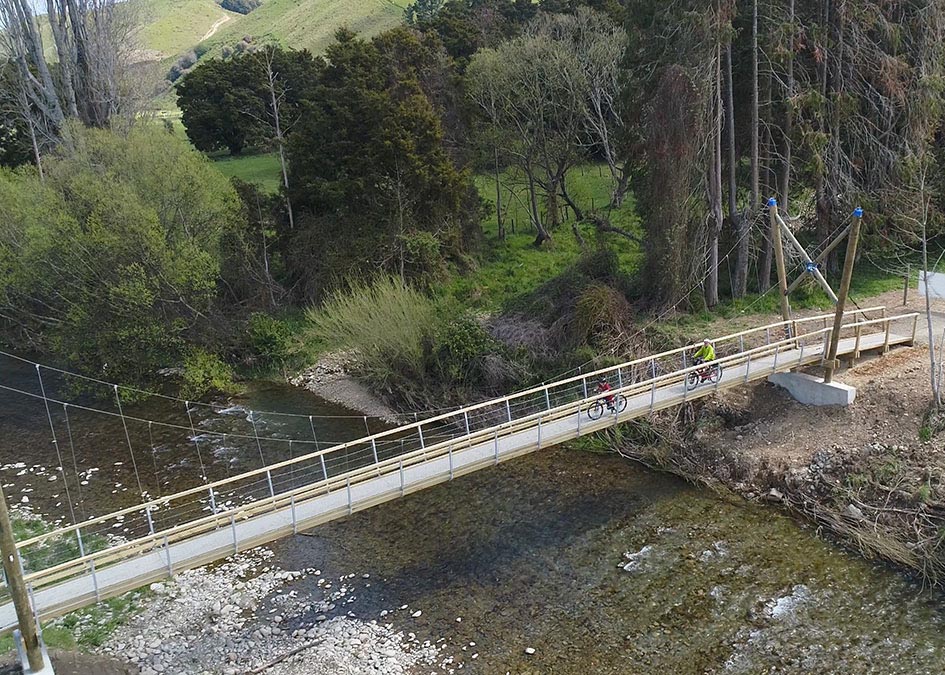Cyclists on a swing bridge using FRP mini mesh grating.
