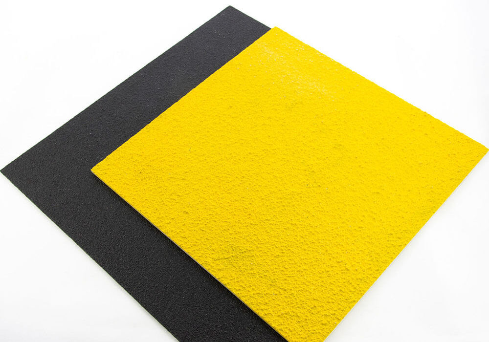 Two sample pieces of FRP Anti-Slip Flat Sheets stacked on each other, one yellow and one black.