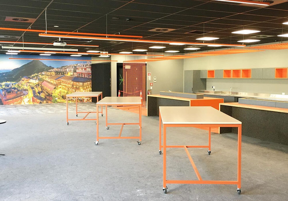 Orange FRP guarding mesh used as a partition in interior office space.
